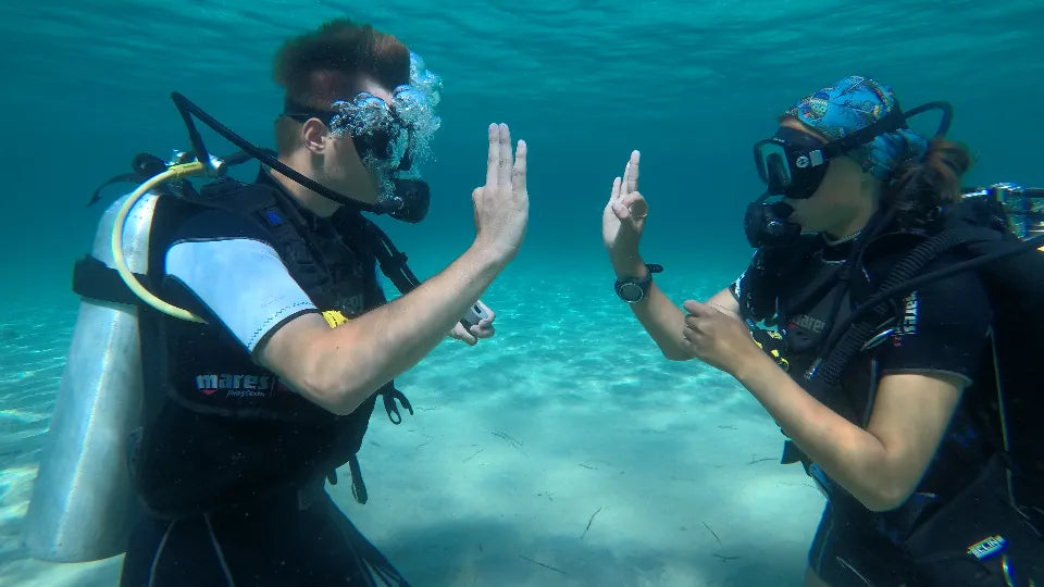 Beginner scuba diving in Nikiti, Greece with instructor briefing on the beach