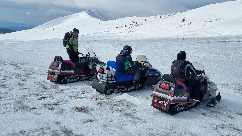 Rider on a snowmobile through forest near the Petrohan Pass