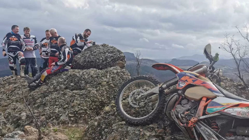 Guide leading an enduro motorcycle ride near Bansko on a dirt road