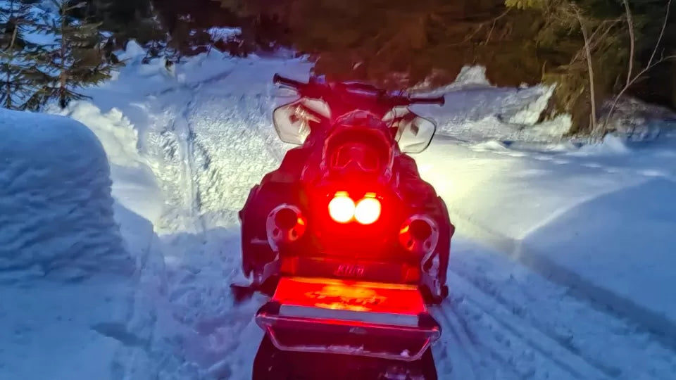 Participant in helmet and gear before a night snowmobile tour in Petrohan