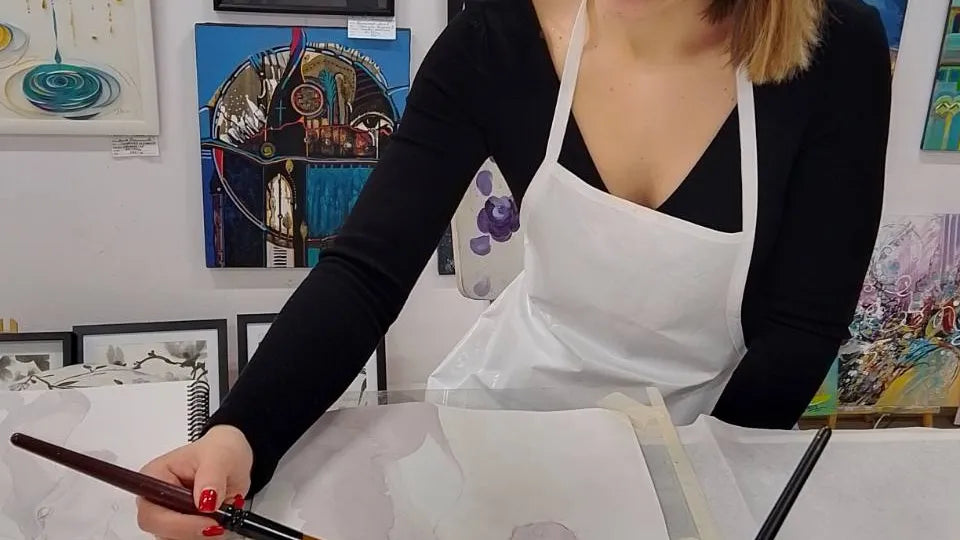Participant painting with red wine on paper during an art class in Sofia
