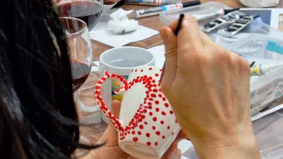 Decorating a mug and saucer set at a porcelain painting workshop