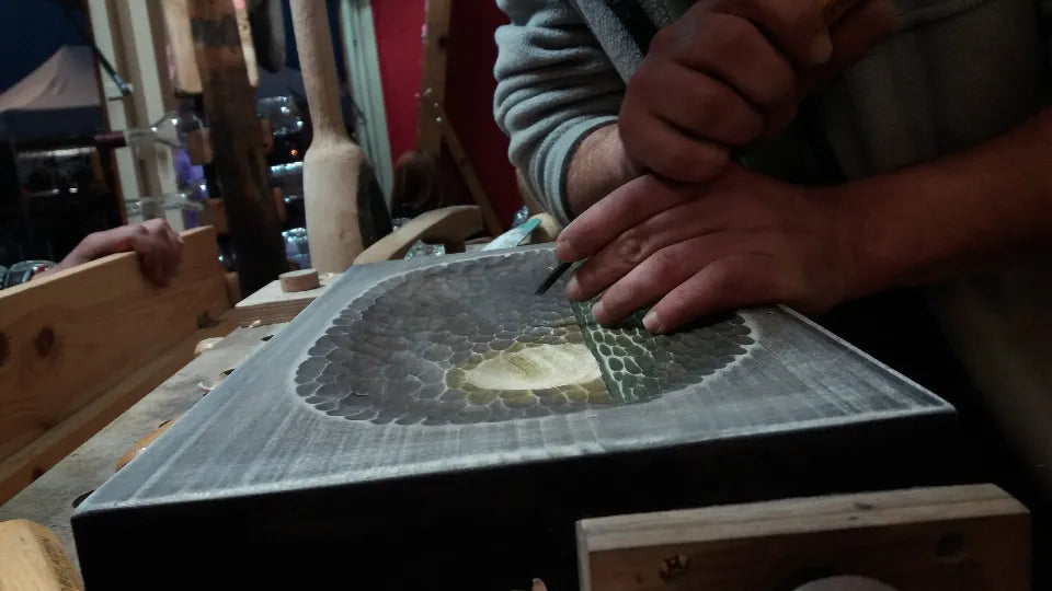 Participant carving a wooden ornament with a master at The House, Veliko Tarnovo