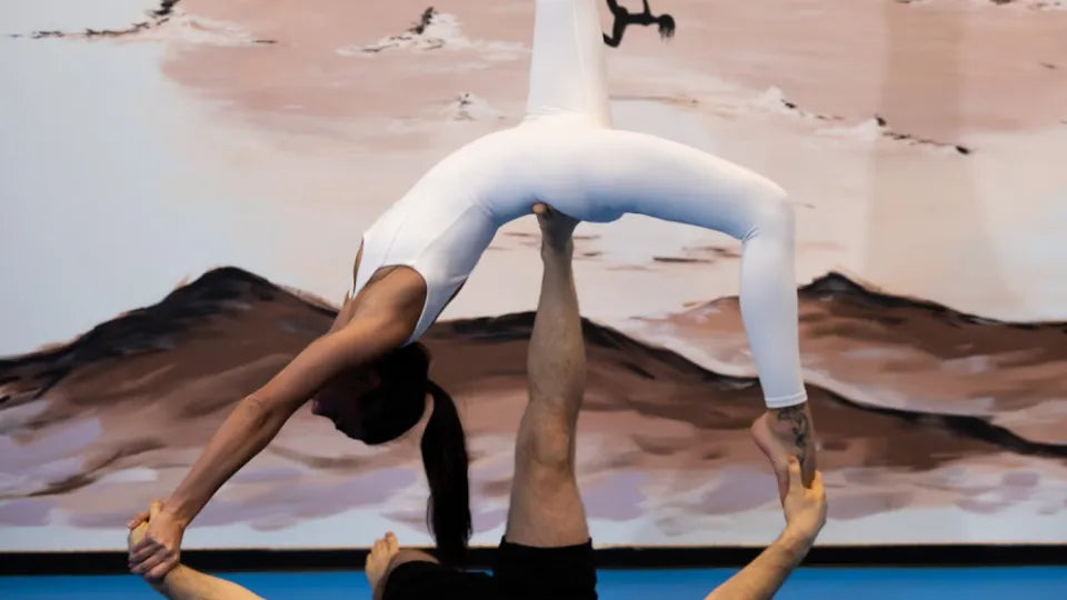 Couple practicing acro yoga balance in a Sofia studio