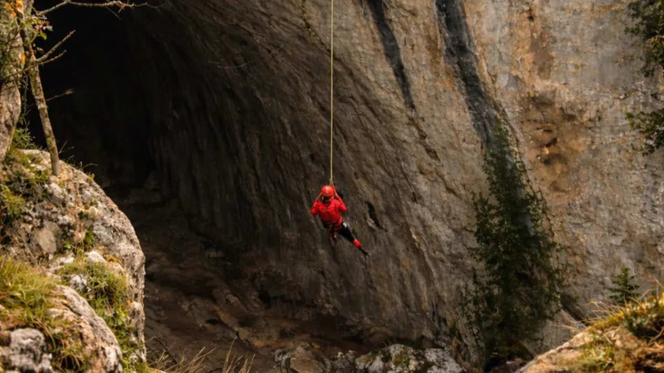 Swinging through a pendulum jump under natural light inside Prohodna Cave